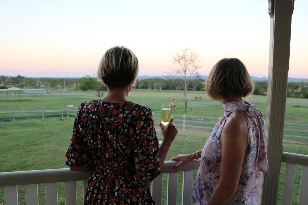 People standing on verandah looking out over Summer Land Camel farm.